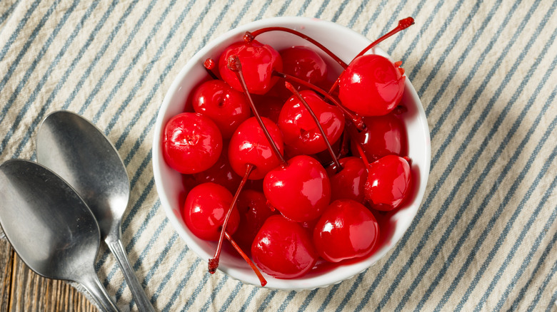 bowl of maraschino cherries on striped napkin