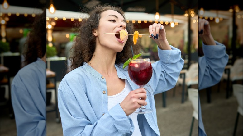 woman eating fruit skewer