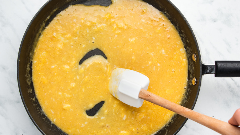 partially scrambled eggs in pan