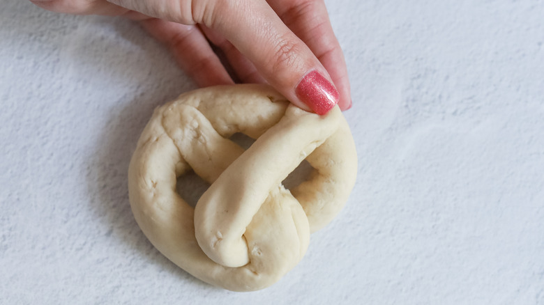 hand folding pretzel dough