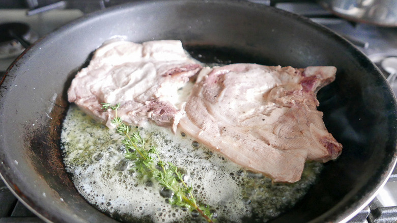 pork chops cooking in skillet