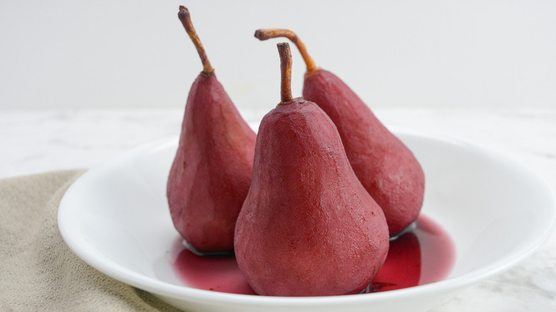 three red wine-soaked pears