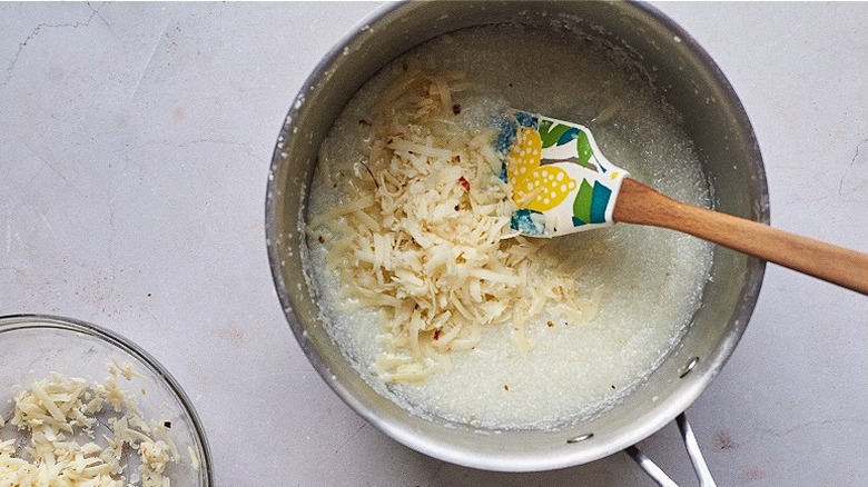 stirring cheese into grits