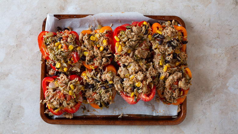 Stuffed peppers on baking sheet with turkey filling