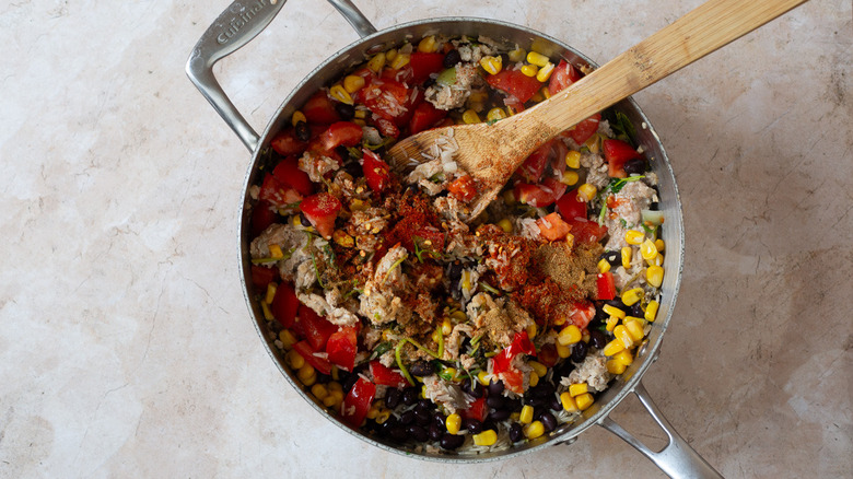 Ground turkey mixture in pan with wooden spoon