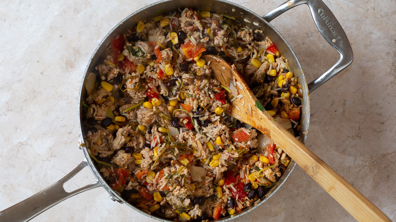 Ground turkey mixture in pan with wooden spoon