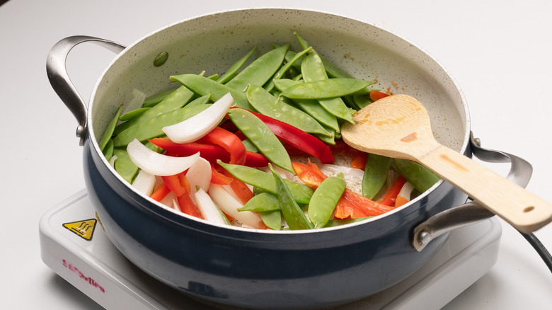 stir-frying vegetables in a pan