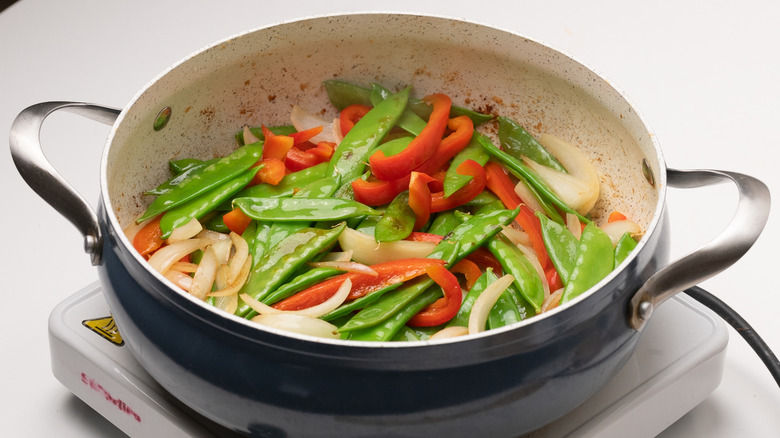 stir-frying vegetables in a pan