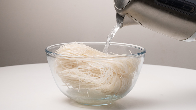 pouring hot water on noodles