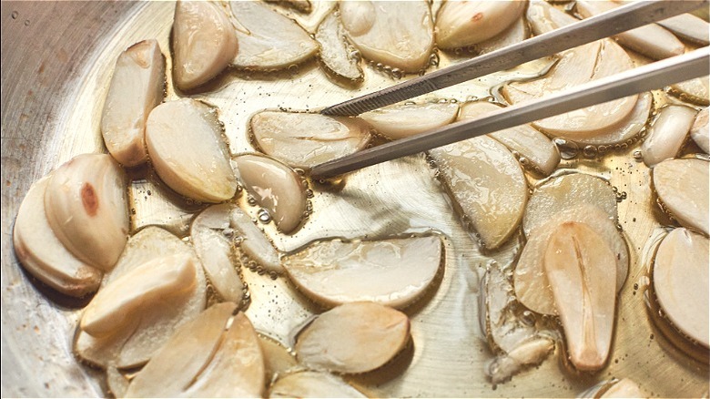 sauteeing garlic slices in oil