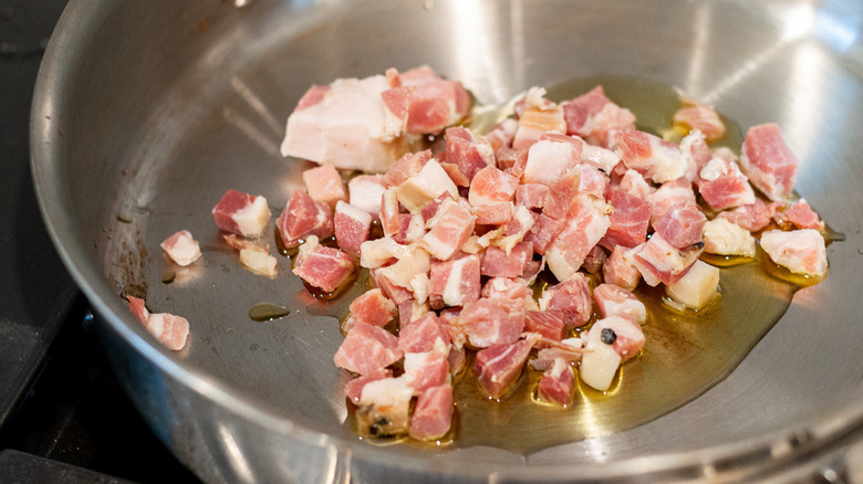 guanciale pieces cooking in skillet