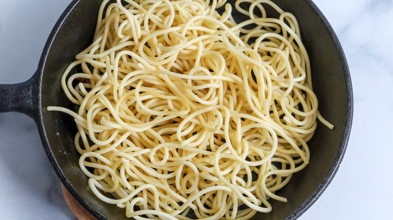 cooked spaghetti in black pan