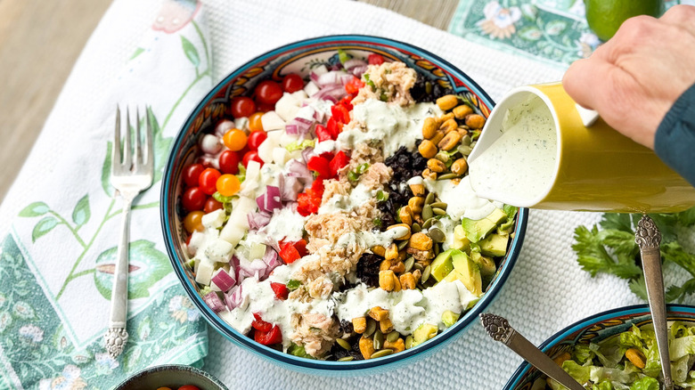 Pouring dressing over salad 