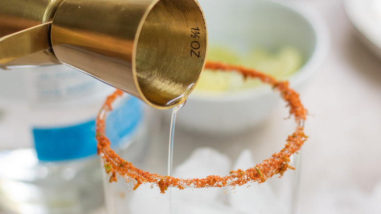 liquid pouring into cocktail glass