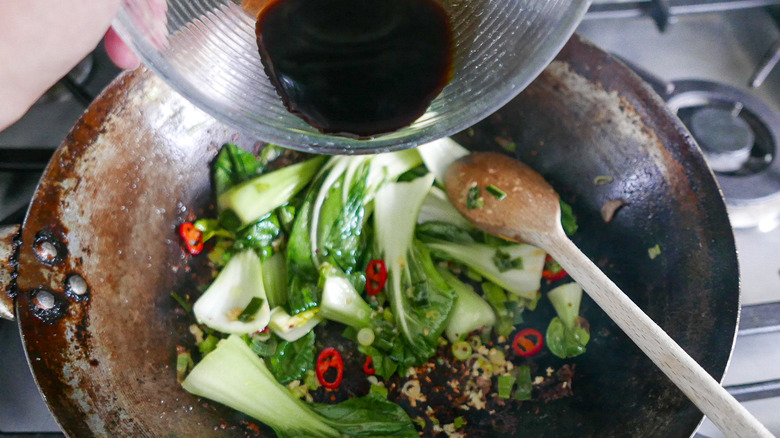 adding sauce to stir-fry veggies