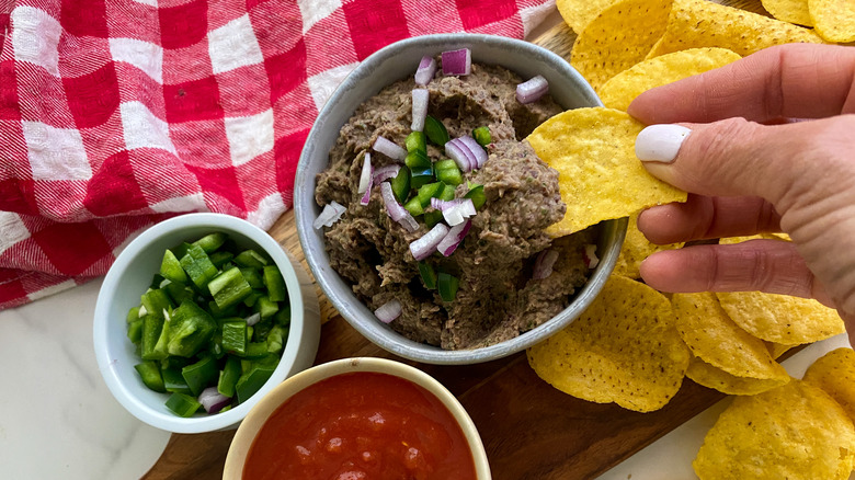 chip dipping into black bean dip