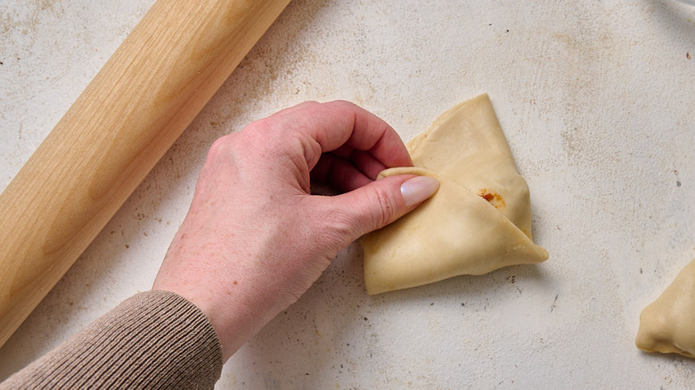folding samosa dough into triangles