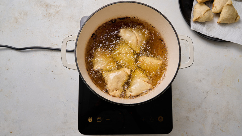 frying samosas in large pot