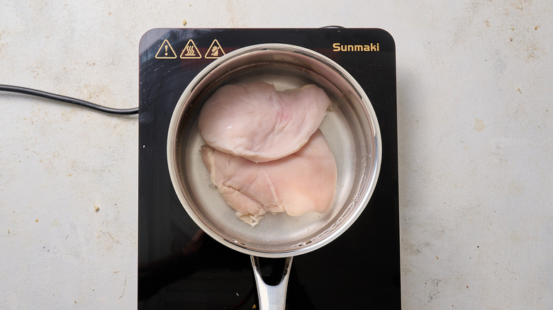 chicken covered with water in pot