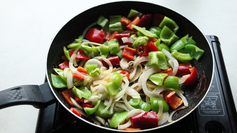 onion and peppers in skillet