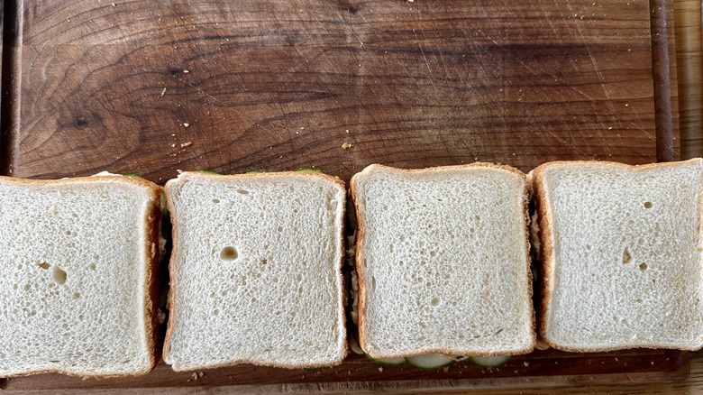 whole cucumber sandwiches on cutting board