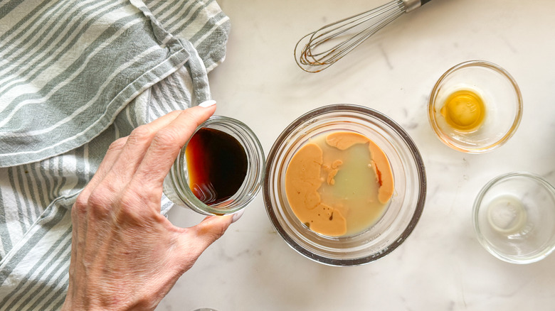 hand pouring soy sauce