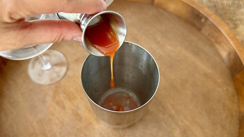 adding hot sauce to shaker