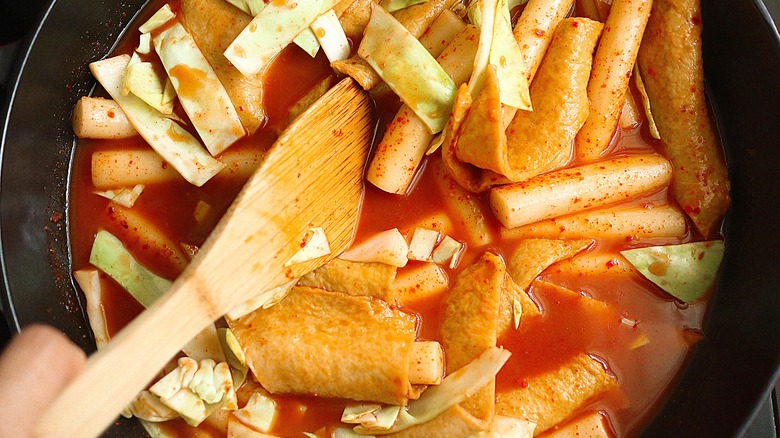 mixing tteobokki ingredients in skillet 