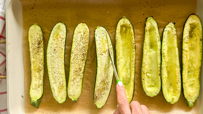 hand cutting into the zucchini