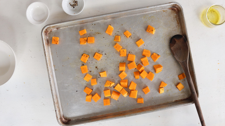 seasoned raw butternut squash on a baking sheet