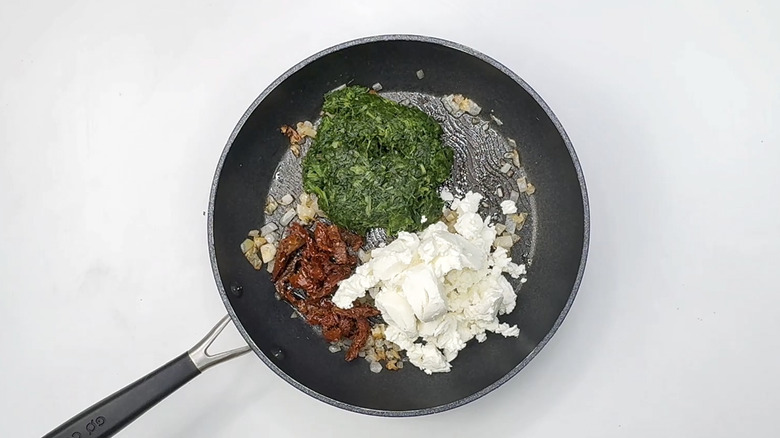 spinach, sun-dried tomatoes, and cheese in pan