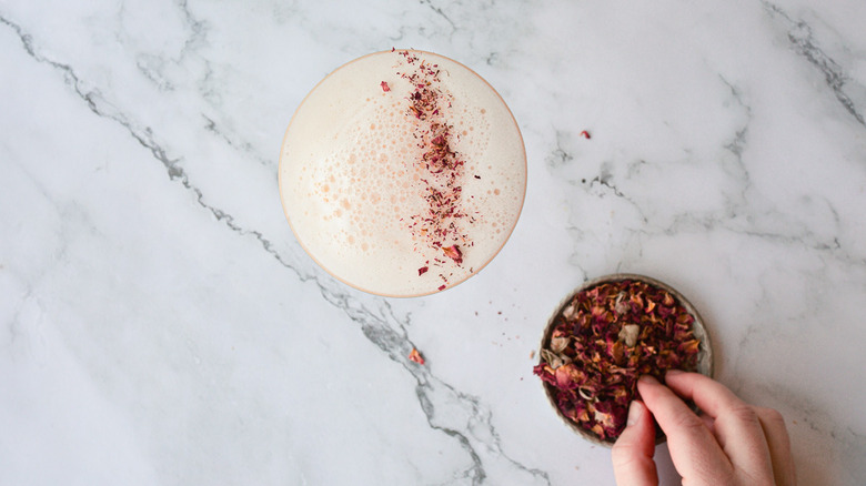 garnishing drink with rose petals