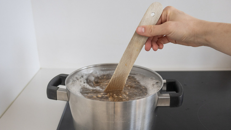 hand stirring farro in pot