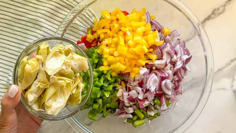 adding artichokes to bowl