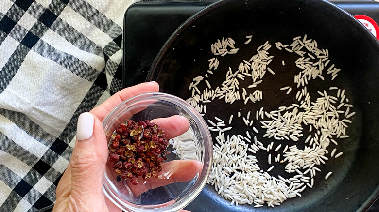 adding peppercorns to pan