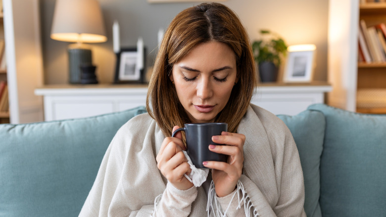 A poorly woman drinking tea.