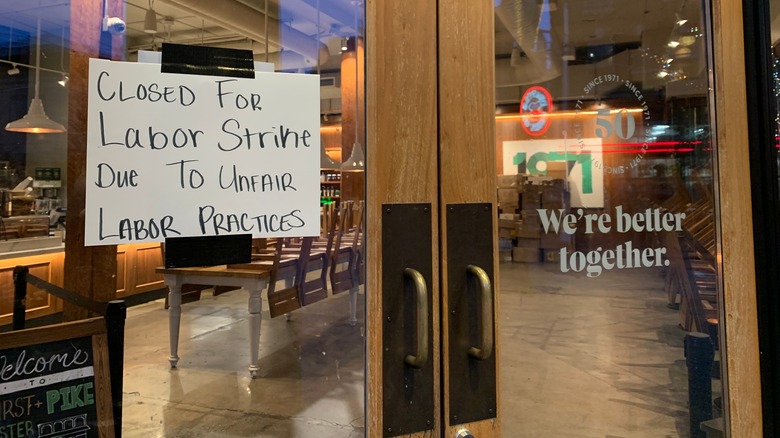 Starbucks window with a juxtaposition of corporate together language and a notice of a strike