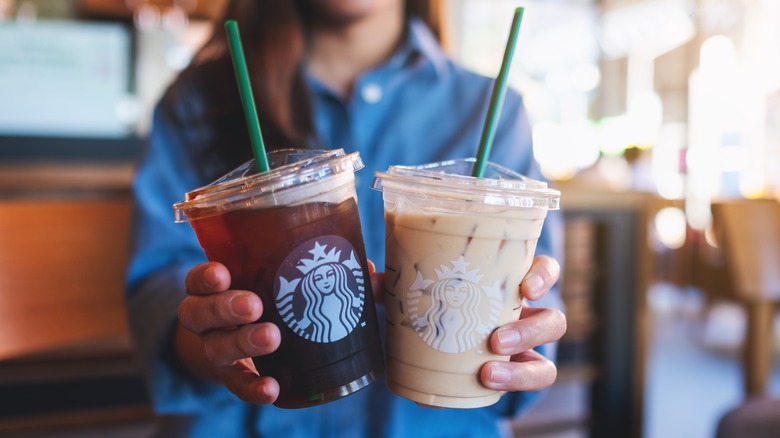 woman holding Starbucks iced coffees