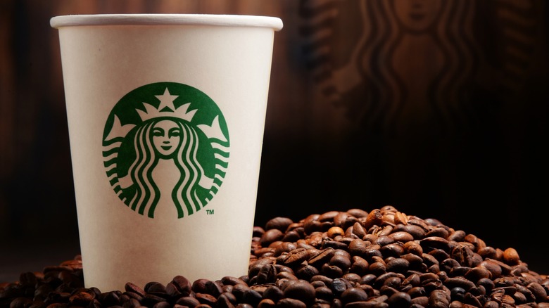 Starbucks paper cup with coffee beans