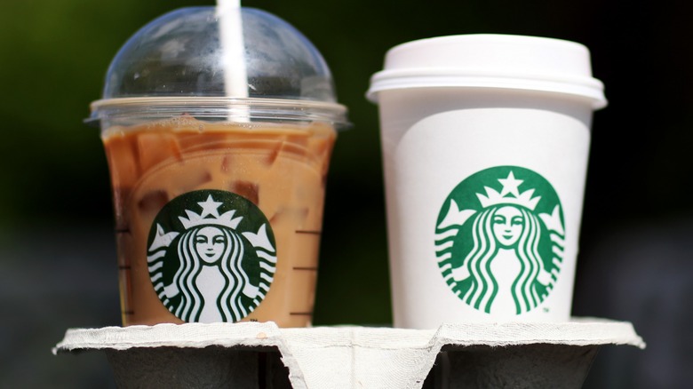 A Starbucks hot drink next to a Starbucks iced drink