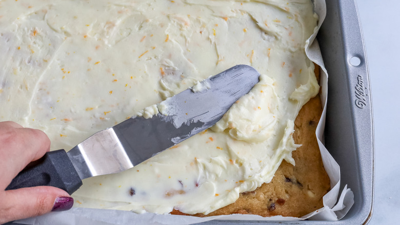 frosting being spread over blondies