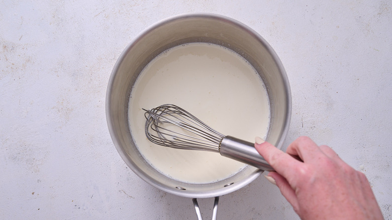 whisking cream in saucepan