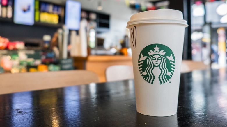 A paper Starbucks branded cup on a bar top