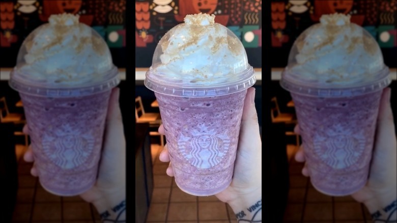 a person holding a berry frappe