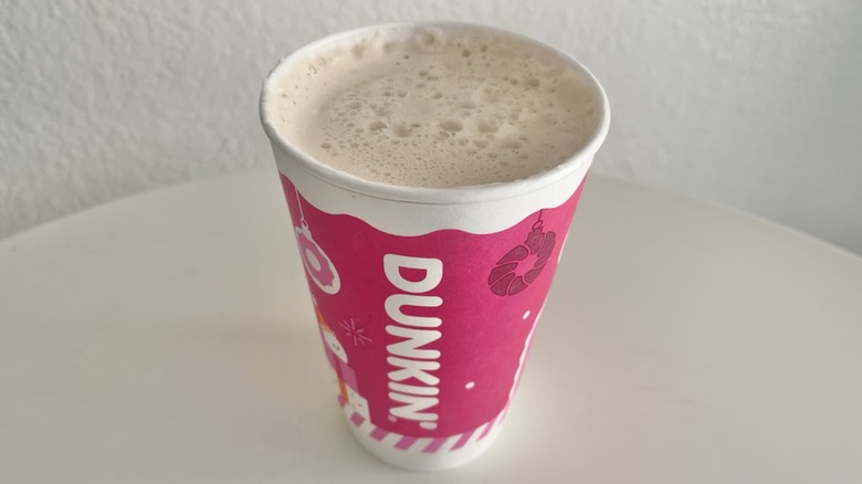 A Dunkin hot chai latte fills a cup.