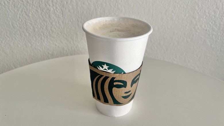 A Starbucks hot chai latte is in a cup on a white table.