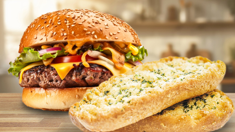 Burger and garlic bread on table