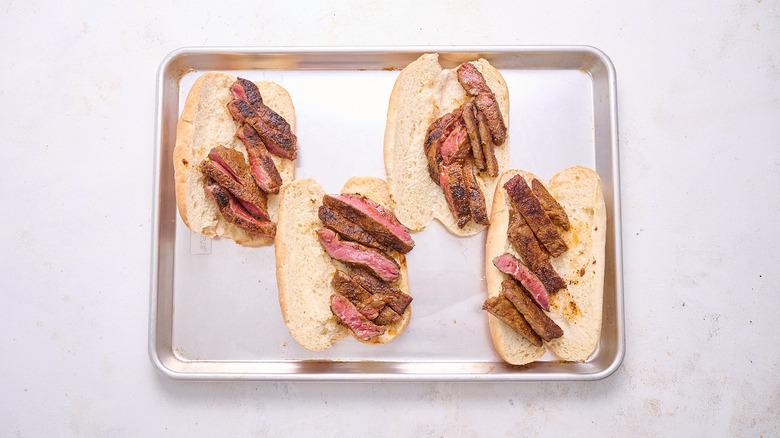 adding steak to hoagie rolls