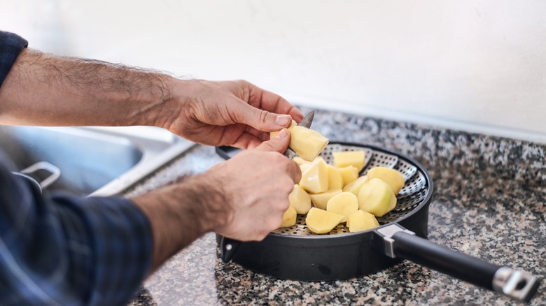 Man cutting potatoes and putting on steam basket