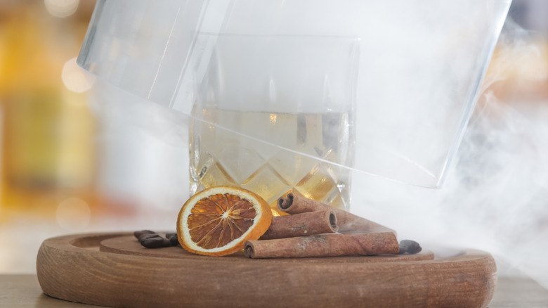 A smoked cocktail with cinnamon sticks